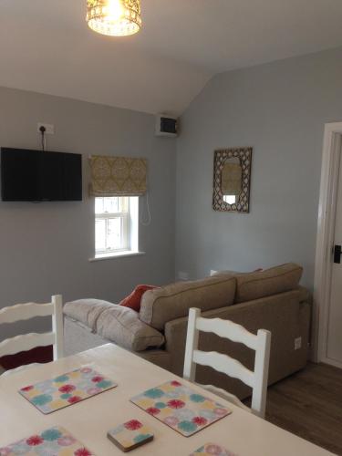 a living room with a couch and a table and chairs at 'Uncle Owenie's Cottage' in Crossmaglen