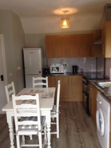 a kitchen with a table and chairs and a refrigerator at 'Uncle Owenie's Cottage' in Crossmaglen