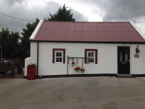 a small white building with a red roof at 'Uncle Owenie's Cottage' in Crossmaglen