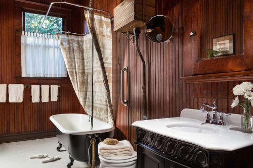 een badkamer met een wastafel, een toilet en een bad bij Magnolia Springs Bed and Breakfast in Magnolia Springs