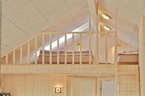 a room with a staircase with bunk beds at Luksus-poolhus L21 in Harboør