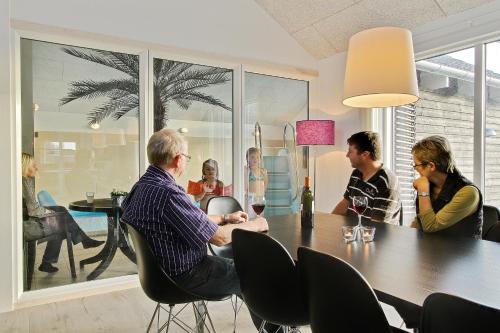 a group of people sitting around a table at Luksus-poolhus L21 in Harboør