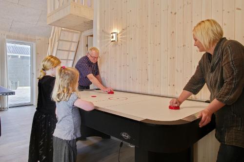 a group of people standing around a ping pong table at Luksus-poolhus L21 in Harboør