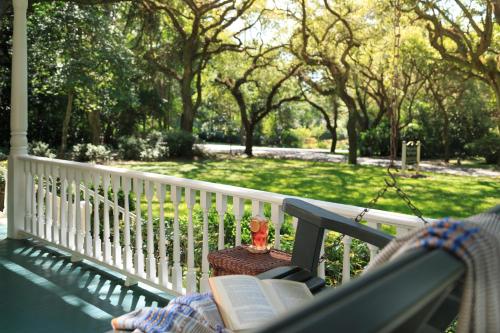a book sitting on a bench on a porch at Magnolia Springs Bed and Breakfast in Magnolia Springs