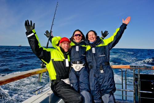 a group of three men on a boat in the ocean at Lyngen Experience Lodge in Nord-Lenangen