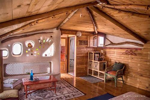 a room in a log cabin with a couch and a table at Casa Inspirada in Los Estancos