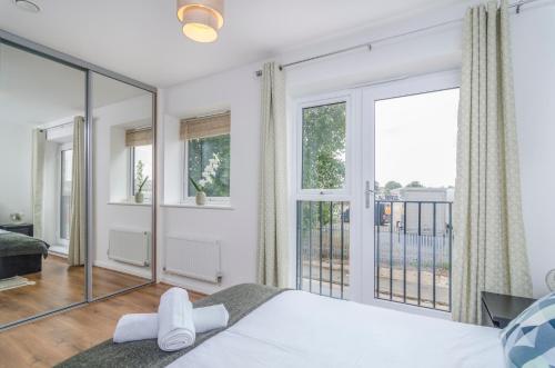 a bedroom with a bed and large windows at The Central Lodge in Dartford