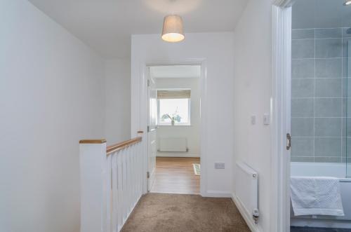 a hallway with a bathroom with a sink and a tub at The Central Lodge in Dartford