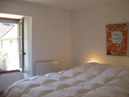 a white bed in a room with a window at La Cour in Flavigny-sur-Ozerain