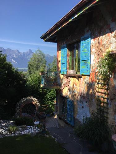 a house with blue shutters on the side of it at Casa toscana in Thun
