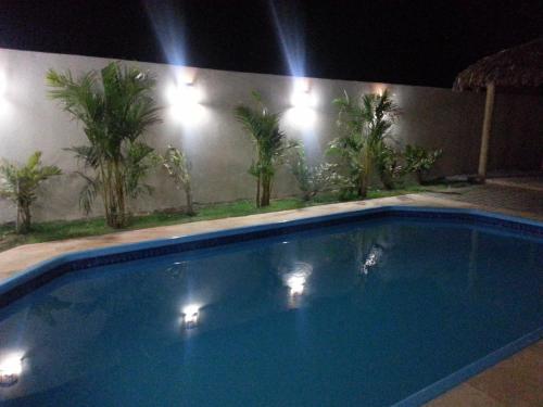 a large blue swimming pool at night with lights at Pousada Brisa Do Pontal in Fortim
