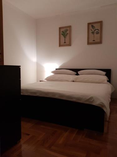 a bedroom with a bed with white sheets and pillows at City Inn Apartment in Osijek