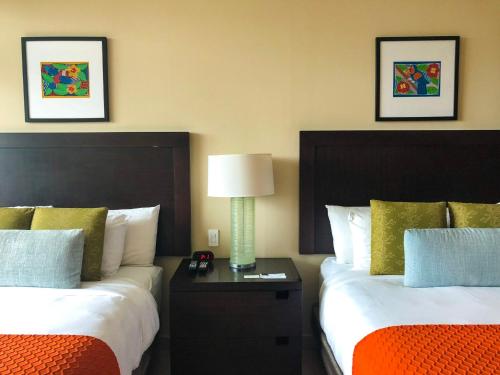 a hotel room with two beds and a table with a lamp at Summit Rainforest Golf Resort & All Inclusive in Paraíso