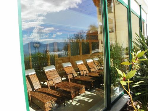 a group of wicker chairs and tables in a window at Hotel Finkennest - Panoramic Garden Resort in Schenna