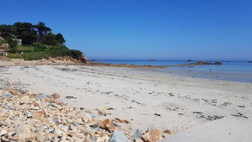une plage avec un tas de rochers dessus dans l'établissement Ty Jeanne, le charme de la pierre au coeur du village, à Plougasnou