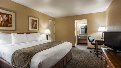 Habitación de hotel con cama y TV de pantalla plana. en Best Western Grants Pass Inn, en Grants Pass