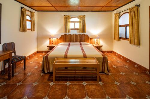 a bedroom with a bed and two windows at Regis Hotel Spa in Panajachel