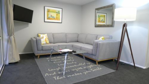 a living room with a couch and a table at Lugano Motor Lodge in Blenheim
