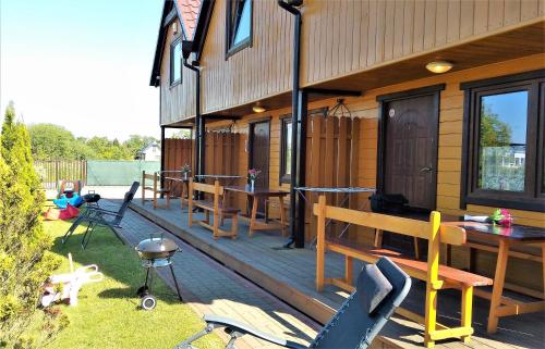 a house with a wooden deck with a table and chairs at Słoneczny Zakątek in Sarbinowo