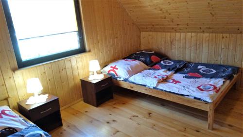 a room with a bed in a cabin with two lamps at Słoneczny Zakątek in Sarbinowo