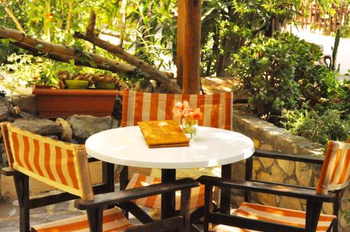a table with two chairs and a vase on it at Hotel Sofia in Matala