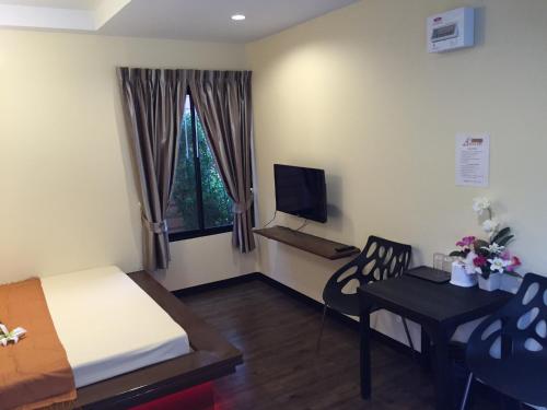 a bedroom with a bed and a table and a television at Angie Resort at Sapan Mai in Bangkok