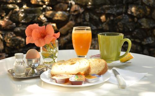 a table with a plate of bread and two cups of orange juice at Hotel Sofia in Matala
