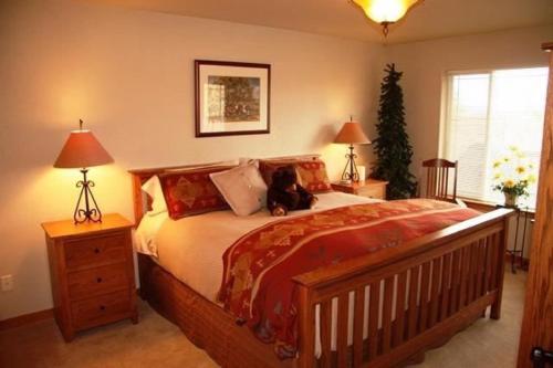 a bedroom with a large bed with a dog sitting on it at Running Y Ranch Townhouse in Klamath Falls