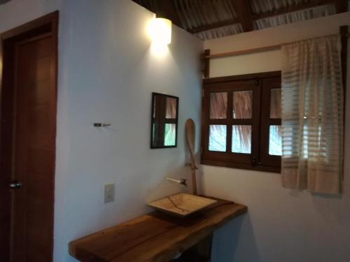 a bathroom with a wooden counter and a window at Cabañas La Isla Chacahua in Guayabas