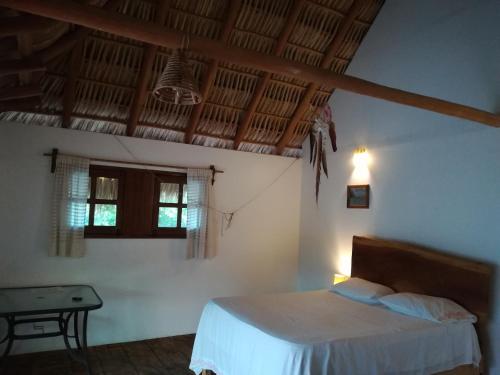 a bedroom with a bed and a table in a room at Cabañas La Isla Chacahua in Guayabas