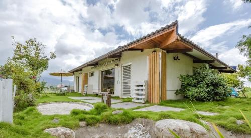 a small white house with a grass yard at 靜夜星空-8人包棟 in Wande