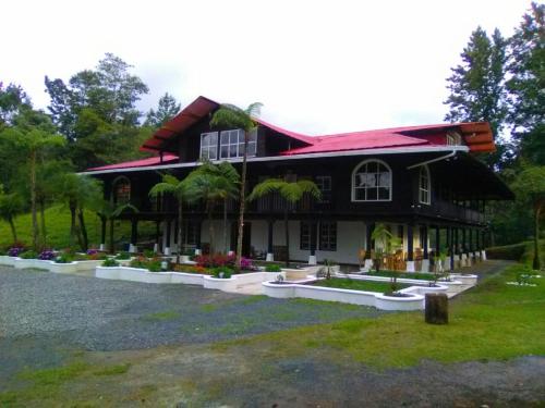 a black house with a red roof at Hotel en Finca Chijul, reserva natural privada in San Juan Chamelco