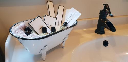 a container filled with cosmetics sitting on top of a sink at Íslandsbærinn /Old Farm in Akureyri