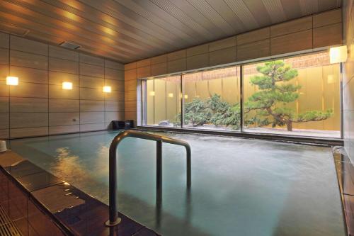 a large swimming pool in a building with a window at Urban Hotel Kyoto Nijo Premium in Kyoto