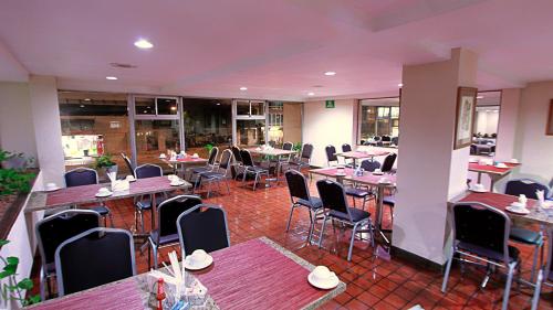 um restaurante vazio com mesas, cadeiras e mesa em Hotel Ambassador em San José