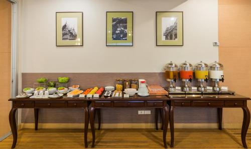 two tables in a room with food and drinks at Asoke Residence Sukhumvit by UHG in Bangkok