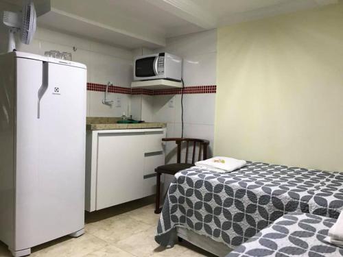 uma pequena cozinha com uma cama e um frigorífico branco em Hostel Trem de Minas em Belo Horizonte