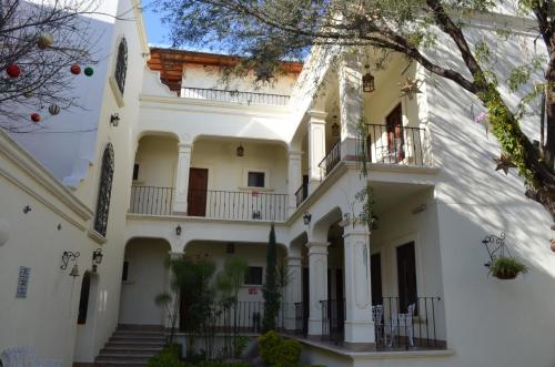 a large white house with stairs and a balcony at Hotel Mariazel in Bernal