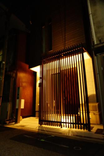 a gate on the side of a building at night at 難波西villa in Osaka