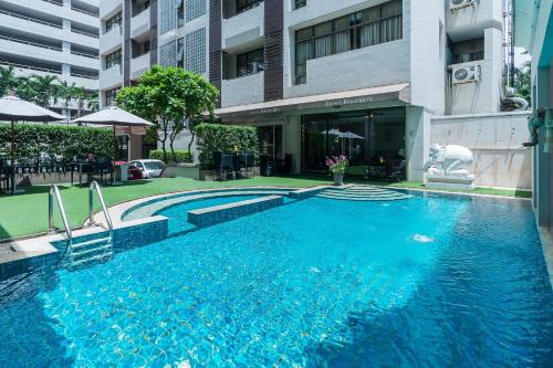 a large blue swimming pool in front of a building at Asoke Residence Sukhumvit by UHG in Bangkok