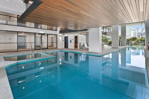 - une grande piscine d'eau bleue dans un bâtiment dans l'établissement Hope Street Apartments by CLLIX, à Brisbane