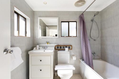 a bathroom with a toilet and a sink and a tub at Pyrmont Self-Contained Terrace House (64 BUL) in Sydney