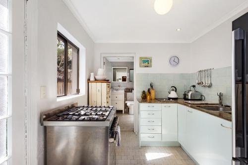 a kitchen with white cabinets and a stove at Pyrmont Self-Contained Terrace House (64 BUL) in Sydney