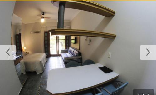 Zimmer mit einem Zimmer mit einem Tisch und einem Bett in der Unterkunft Apto no IlhaFlat em frente Mar in Ilhabela