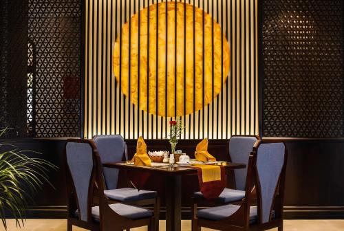 a dining room with a table and chairs and a large light at Laluna Hoi An Riverside Hotel & Spa in Hoi An