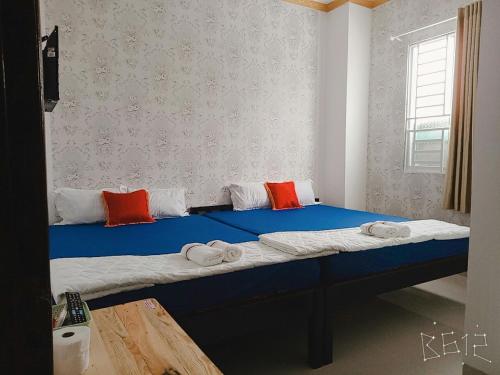 sypialnia z dużym niebieskim łóżkiem z ręcznikami w obiekcie Hanh Phat 2 Guesthouse w mieście Cái Răng