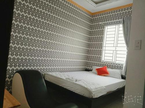a small bedroom with a bed with a window at Hanh Phat 2 Guesthouse in Cái Răng