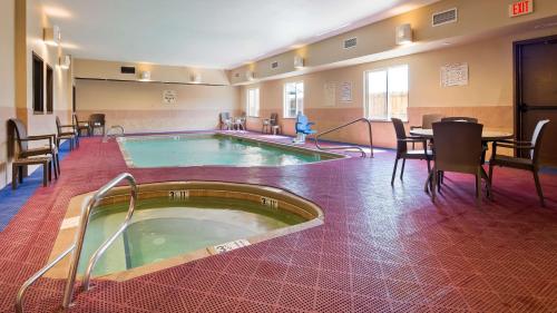 una piscina en una habitación con sillas y mesa en Best Western Plus Montezuma Inn and Suites en Las Vegas