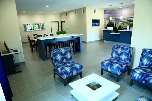 Prairieville 的住宿－Americas Best Value Inn & Suites-Prairieville，一间设有蓝色椅子和桌子的等候室