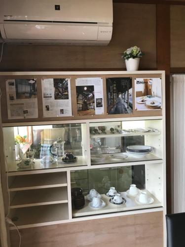 a glass display case with dishes and other items at Kizuna no Ie in Uozu